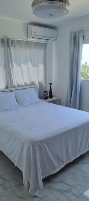 Room with double bed, air condition and ceiling fan.