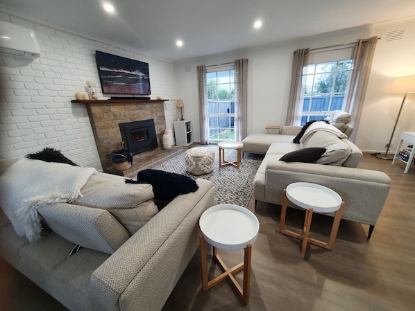 Open plan lounge with adjustable couches, gas log fire, free pay TV, board games