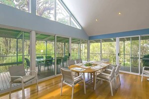 Dining area. The vaulted ceilings and large windows make you feel perched among the trees and surrounded by nature when spending time in this space.