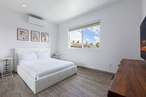 Bedroom 3: Full size bed with attached bathroom, smart TV, and closet. 