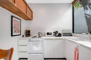 The kitchen is stocked with a full set of appliances including a basic kitchen utensils. 