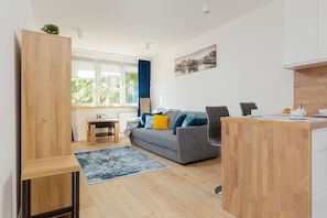 A combined living and dining area with wooden furniture, soft rugs, and plenty of natural light.