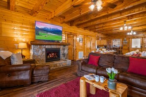 Main level living room equipped with a beautiful fireplace and a 65' Smart TV.