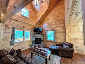 The modern open-concept living area with a gas fireplace featuring a flat-screen TV with a surround sound bar.