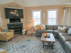 Living Room - Large windows with natural light amplify the high ceilings in the home's open living spaces.