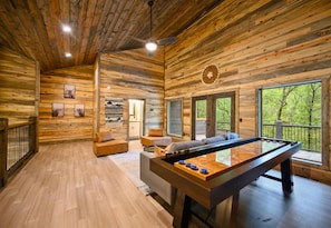 Welcome to your cozy retreat! Sink into the charm of natural wood and let every game of pool have a backdrop of lush forest views