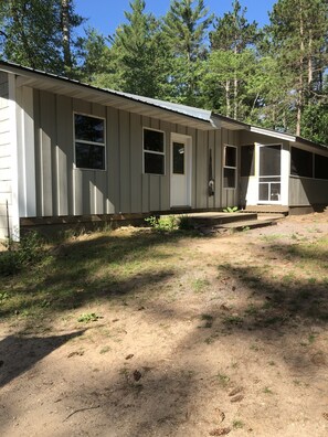 Grey wolf front of cabin