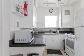 Full kitchen with stove, microwave, and refrigerator.