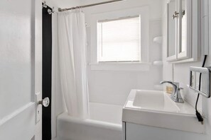 Spacious bathroom with a tub. Shampoo, body wash and conditioner provided