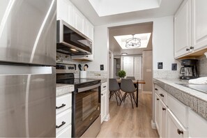 Powderwood 7B: Modern appliances and ample storage in sleek kitchen design.