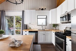 A warm and welcoming kitchen where you can cook, sip coffee, and enjoy the peaceful view of the pines right outside your window — everything you need for a relaxing mountain getaway.