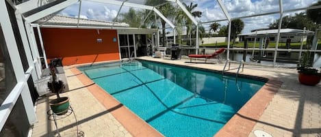 Solar Heated PoolBarbeque on the right with a lounger.Limited pool toys on left in box (condition may vary with use)Lanai entrance is straight ahead.There is a door on the left by the hose reel.There is a door on the right by the potted plant.