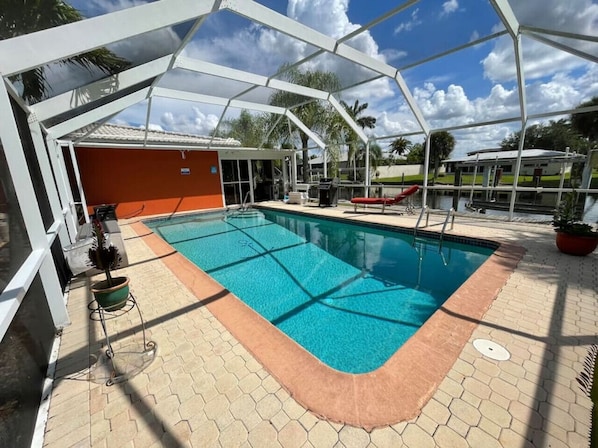 Solar Heated PoolBarbeque on the right with a lounger.Limited pool toys on left in box (condition may vary with use)Lanai entrance is straight ahead.There is a door on the left by the hose reel.There is a door on the right by the potted plant.