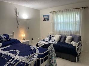 This is the master bedroom looking at the north window from the door of the master bathroom.We have a firm king bed on the left and a twin day bed with a twin trundle underneath.The bed lamps have 3 USB ports for charging your devices.