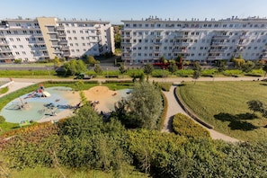 A view of the lush, green outdoor surroundings with walking paths and recreational areas near the apartment complex.