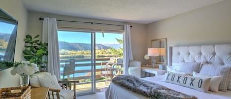 Primary bedroom with king bed, balcony access and pond views