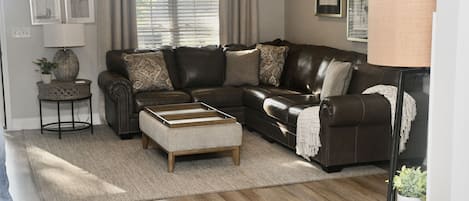 Large family room with leather sectional sofa that seats 6-7 people