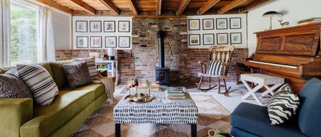 Den with wood burning stove and piano.