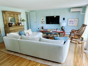 Living room features smart tv and games. (1)