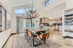 (Main Level) Dining Room and Kitchen. The Dining Table is a unique live edge wood table with lots of space for the whole family to dine or work on a puzzle together.