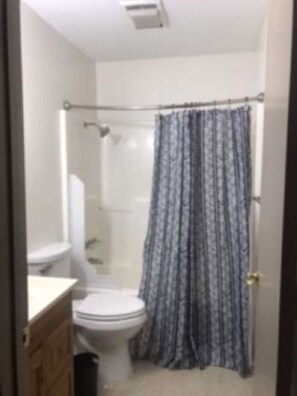 Bathroom with tub/shower, towels and soap 