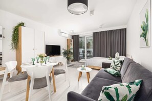 Bright and spacious open-plan living and dining area with a modern table setup and chic gray seating.