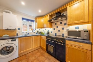 Ground floor: Kitchen with gas Rangemaster, microwave, slimline dishwasher, fridge-freezer and washing machine