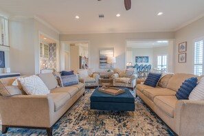 Large living area with wall of windows boasting spectacular view of bay