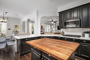 Butcher Block Island, gas stove, and microwave in the kitchen.