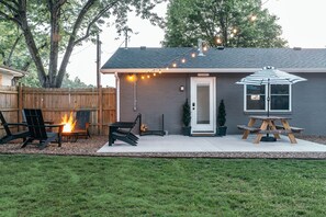 Spacious backyard and patio with picnic table 