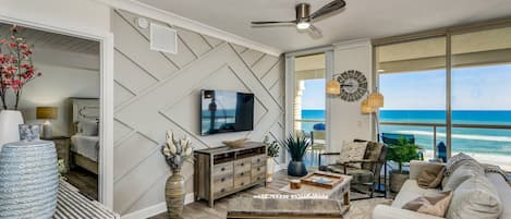 The living room has large flat screen smart TV and Gulf views