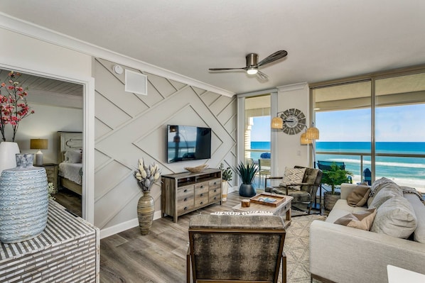 The living room has large flat screen smart TV and Gulf views