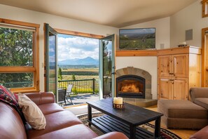 Living space has tv above gas fire place and double doors open up to back patio.