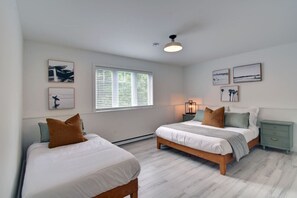 Bright, clean white bedroom featuring two comfortable beds—perfect for families or group stays.