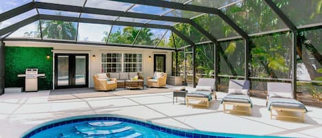 Large pool deck surrounded by lush landscaping 