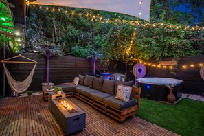 The large backyard  space includes a fireplace, TV, 5-burner grill and hot tub