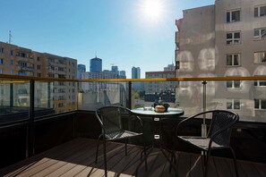 A private balcony with outdoor furniture and a cityscape view, perfect for relaxation.
