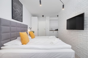A double bed with soft linens and yellow pillows, creating a cozy sleeping area.

