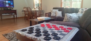 A large game of checkers is ready to be played in the living room area