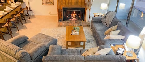 Living room with a gas fireplace, smart tv, and new leather sofas 