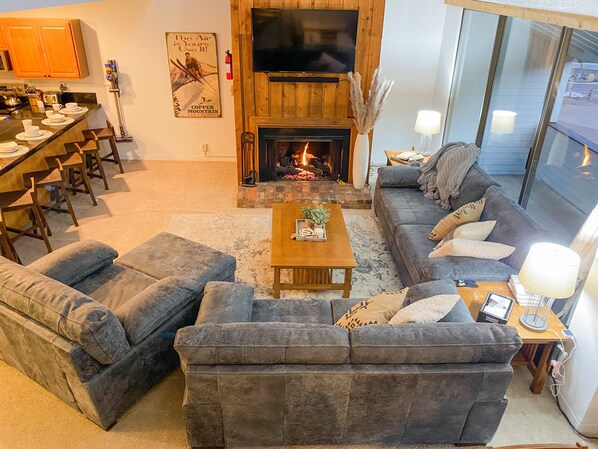 Living room with a gas fireplace, smart tv, and new leather sofas 