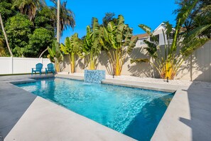 heated pool with waterfall and sun shelf