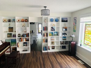 Bookcase along side a big window, bright and vibrant. 