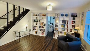 Bookcase along side a big window, bright and vibrant. 