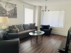 Spacious and comfortable living room, with a 55" Roku TV