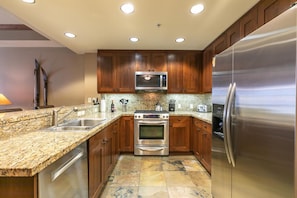 Open kitchen with stainless steel appliances and granite countertops