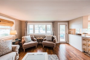 Cozy and inviting living space with a beautiful view of Cobbosseecontee Lake. Relax by the windows or step out onto the deck to enjoy the scenery.