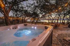 Large hot tub overlooks beautiful entertaining area with sweeping lake view.
