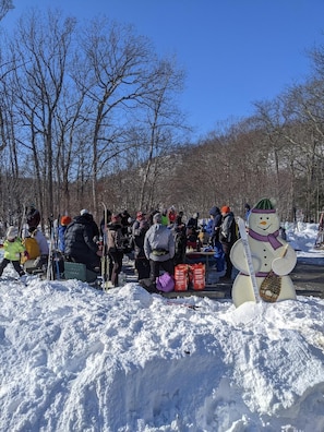 Gathering for Hot Chocolate at the fire pit in Fahnestock Winter Park.