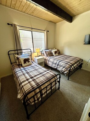 Back room with 1 twin bed, 1 full bed and Smart TV.